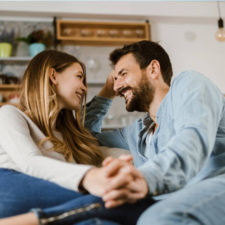 Happy couple embracing at home