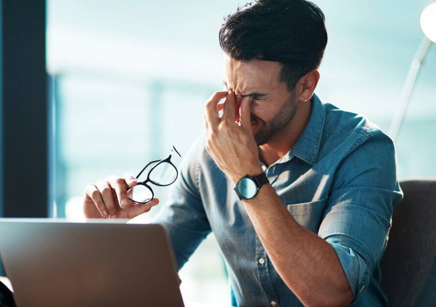 a man at work or at home looking visibly stressed
