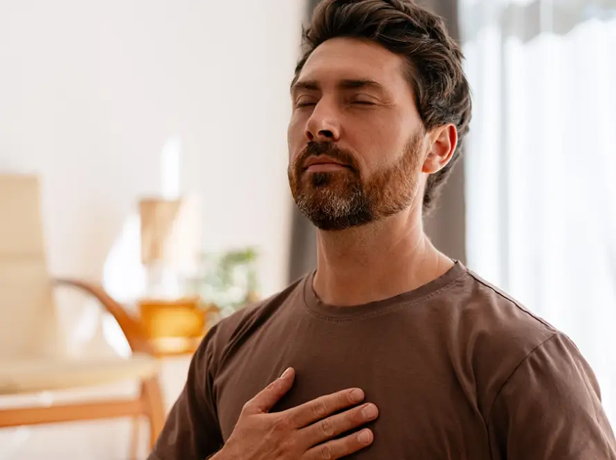Man meditating with hand on chest