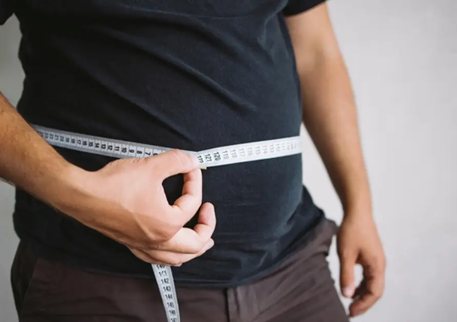 Person measuring waist with tape measure